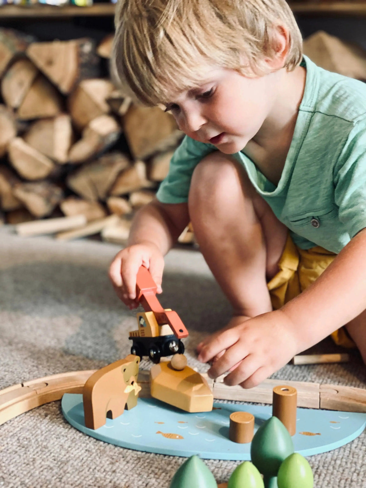 Kind spielt mit Holzzug und Zubehör des Abenteuer Eisenbahn-Sets