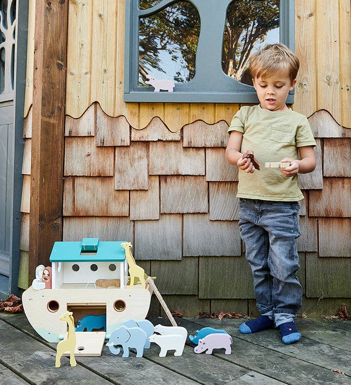 Kind mit grosser Holz Arche Noah und Tierfiguren beim Spielen
