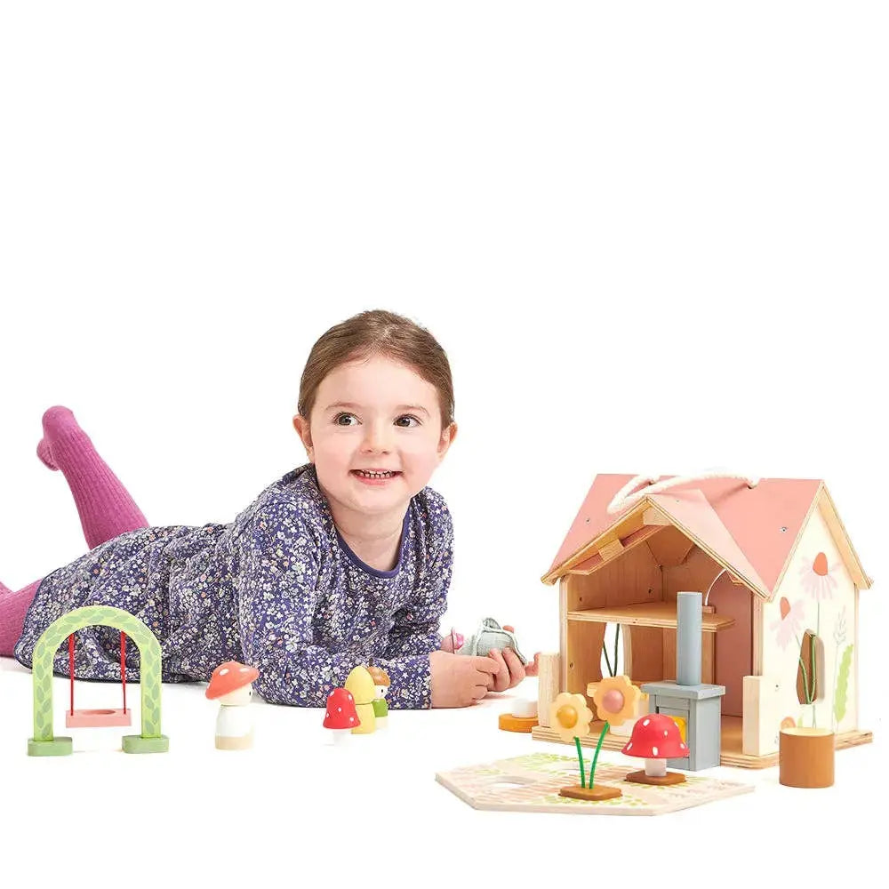Kind spielt mit dem Holzpuppenhaus, Puppen und verschiedenen Möbeln