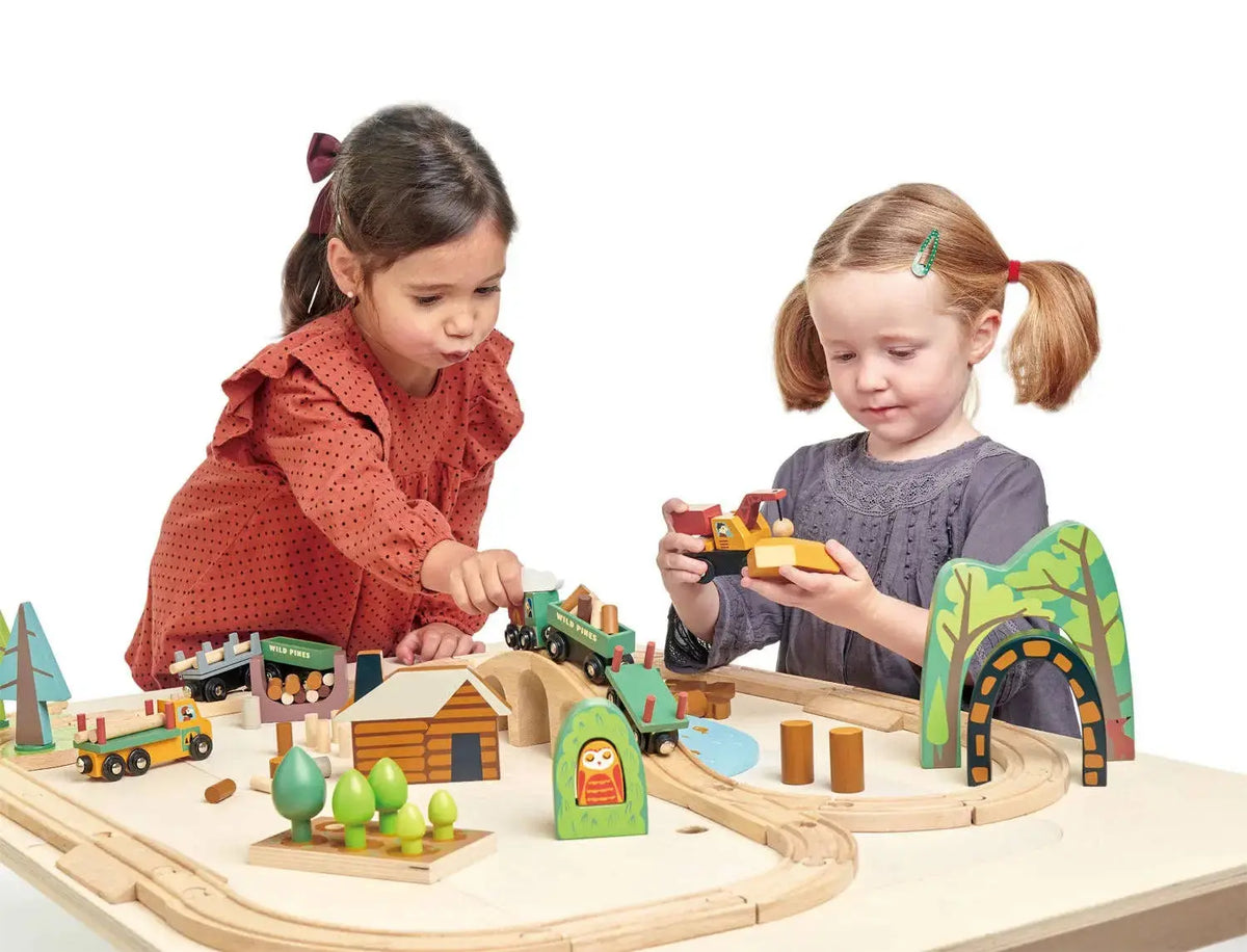 Kinder spielen gemeinsam mit dem Eisenbahn-Set aus Holz und gestalten eine Bahnstrecke
