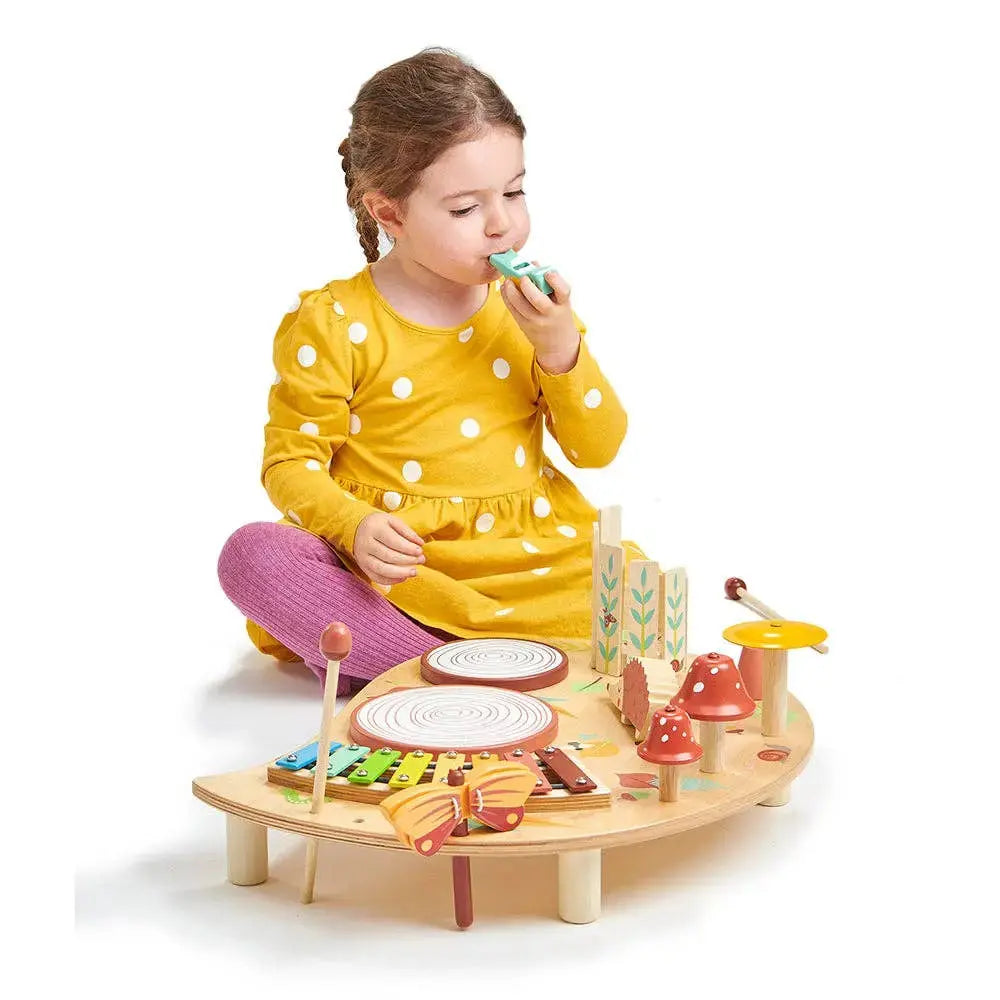 Kind am Musik Aktivitätstisch mit verschiedenen Instrumenten aus Holz