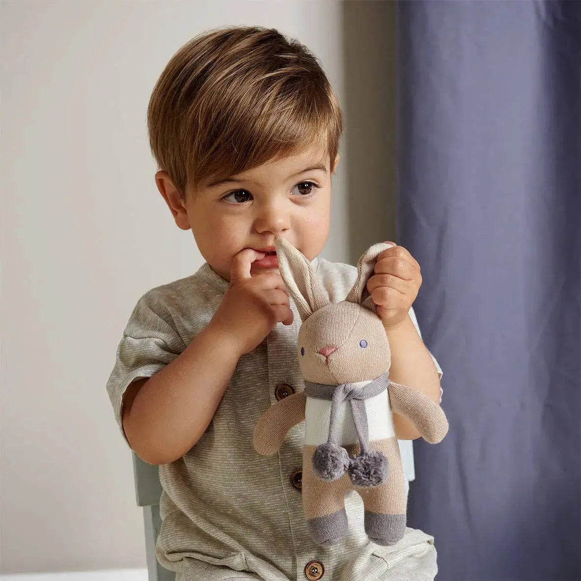 Baby hält eines der weichen Häschen aus dem Geschenkset in den Händen.