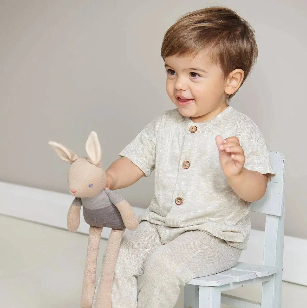 Baby spielt mit einem weichen Häschen und entdeckt das Spielzeug mit den Händen.