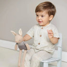 Baby spielt mit einem weichen Häschen und entdeckt das Spielzeug mit den Händen.
