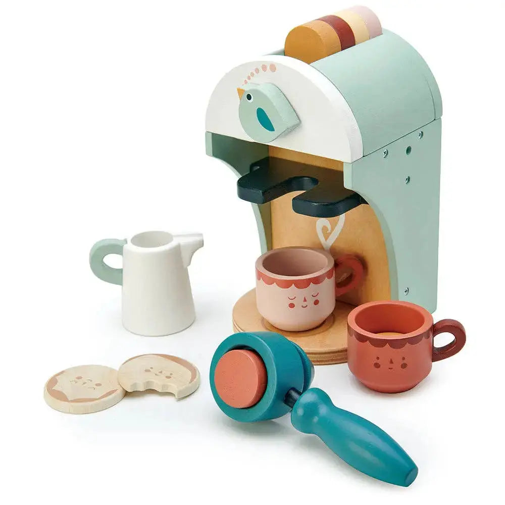 Babyccino Kaffeemaschine mit verschiedenen Tassen, Kaffeekapseln und weiterem Zubehör aus Holz.