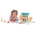 Kind beim fantasievollen Spielen mit Holz Arche Noah und Tierfiguren