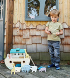Kind mit grosser Holz Arche Noah und Tierfiguren beim Spielen