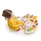 Kind entdeckt die verschiedenen Instrumente am Musik Spielzeugtisch aus Holz