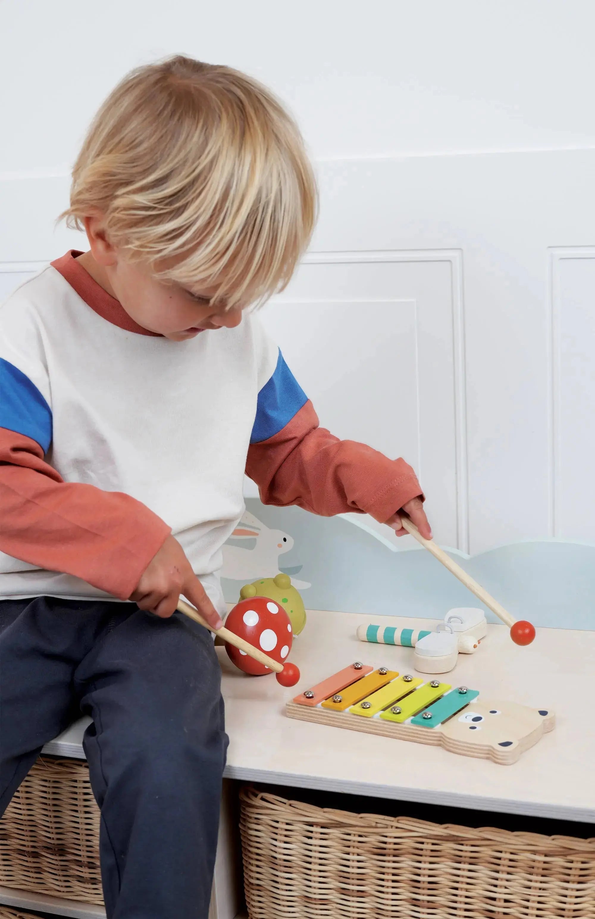 Kind entdeckt spielerisch unterschiedliche Klänge mit einem Instrument aus dem Waldmusik-Set.