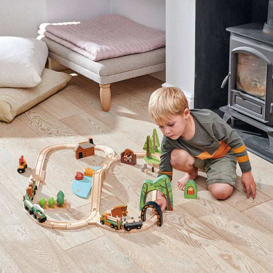 Kind spielt mit dem Abenteuer Eisenbahn-Set aus Holz und baut eigene Strecken