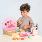 Kinder spielen mit den Süssigkeiten, der Waage und dem Verkaufszubehör des Süsswarenladens.