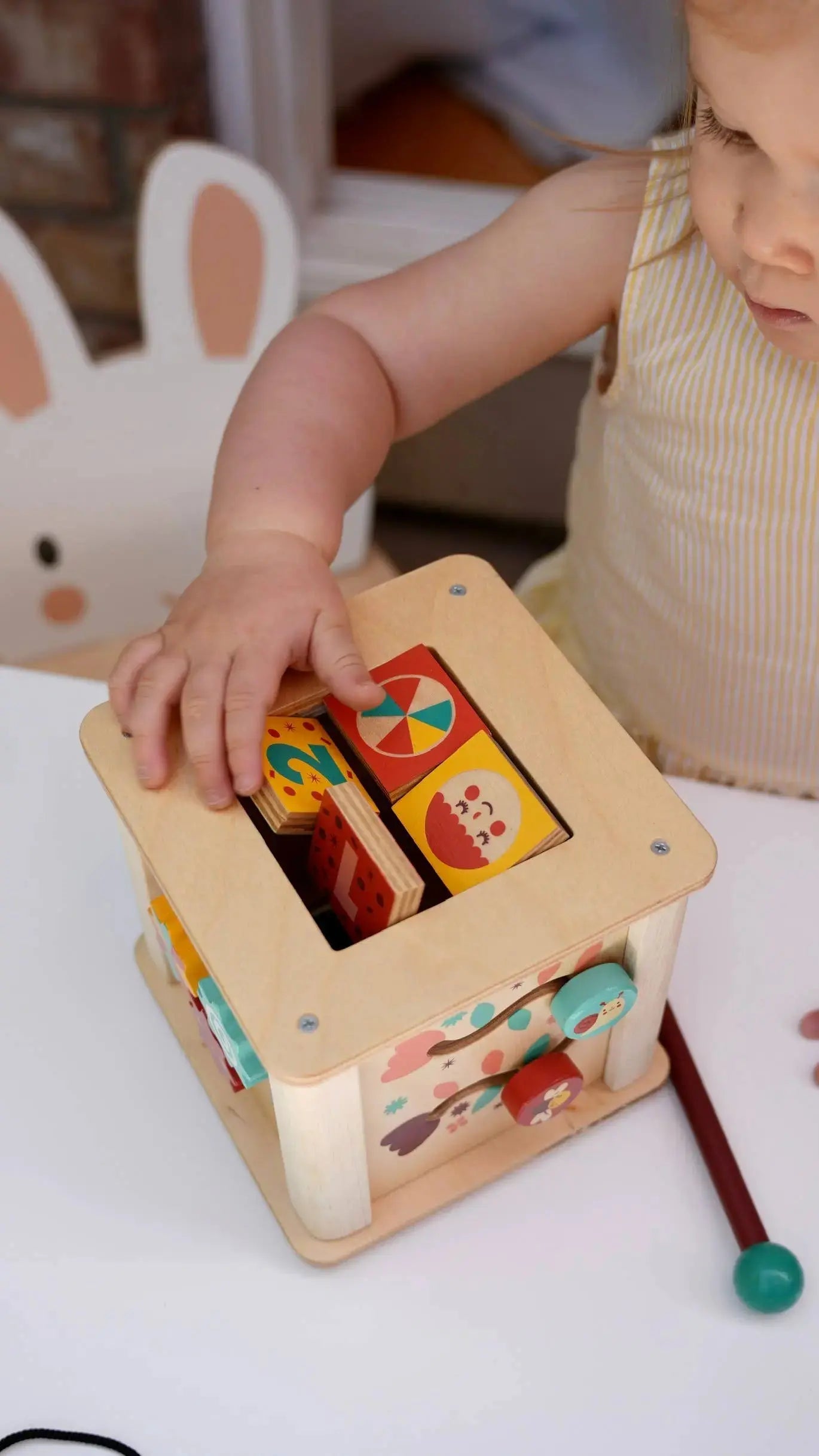Kinderhände beim Spielen mit dem bunten Xylophon am Holz Motorikwürfel