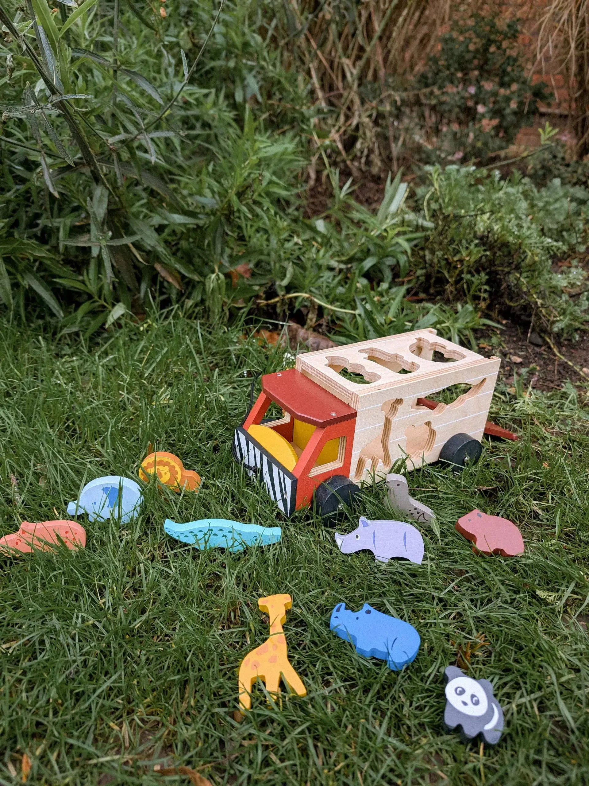 Safari Jeep und bunte Tierfiguren bei einem fantasievollen Spiel im Garten